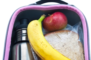 A water bottle, apple, banana, and sandwich in a lunchbox.