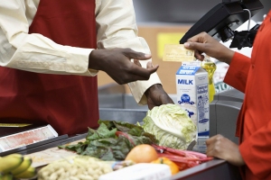 Customer handing membership card to supermarket cashier.